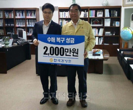 손형배 한국감정원 충북청주지사장(왼쪽)이 25일 이승훈 청주시장에 수해복구 성금 2000만원을 전달한 뒤 기념 사진을 찍고 있다.<한국감정원 제공>